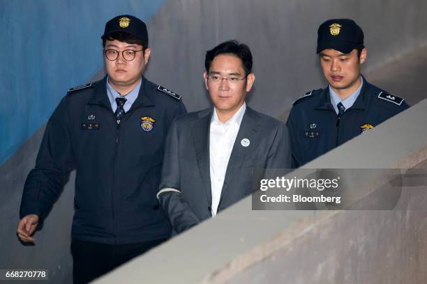 Jay Y. Lee, co-vice chairman of Samsung Electronics Co., center, is escorted by prison officers as he arrives at the Seoul Central District Court in...