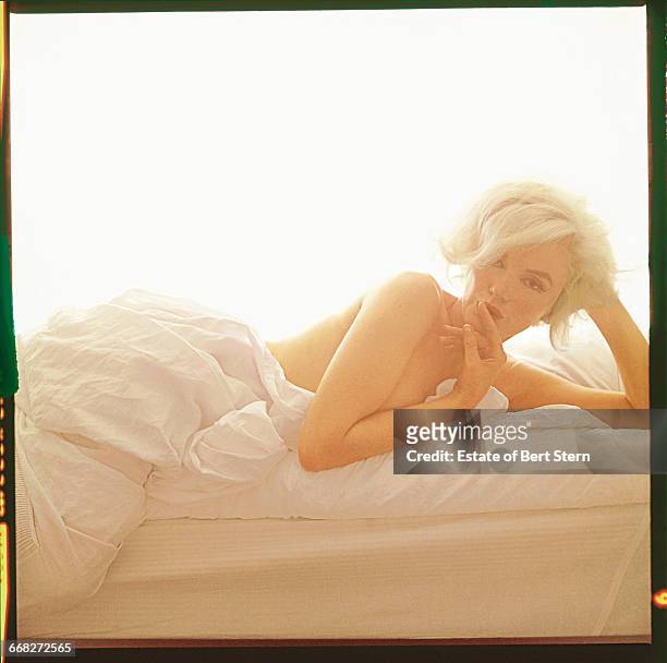 American actress Marilyn Monroe lying naked on a bed, Beverly Hills, California, June 1962. The two sessions for the photoshoot took place in late...