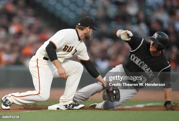 LeMahieu of the Colorado Rockies steals third base under the tag of Conor Gillaspie of the San Francisco Giants in the top of the first inning at...