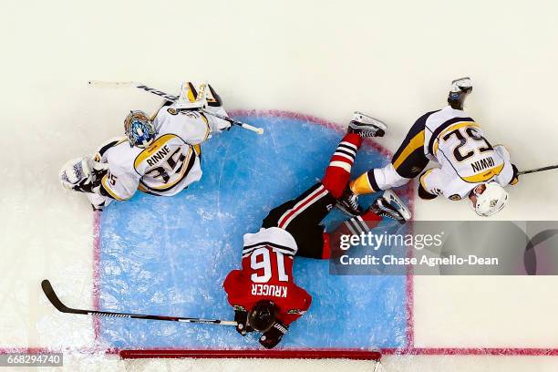 Marcus Kruger of the Chicago Blackhawks trips over Matt Irwin of the Nashville Predators in the third period in Game One of the Western Conference...
