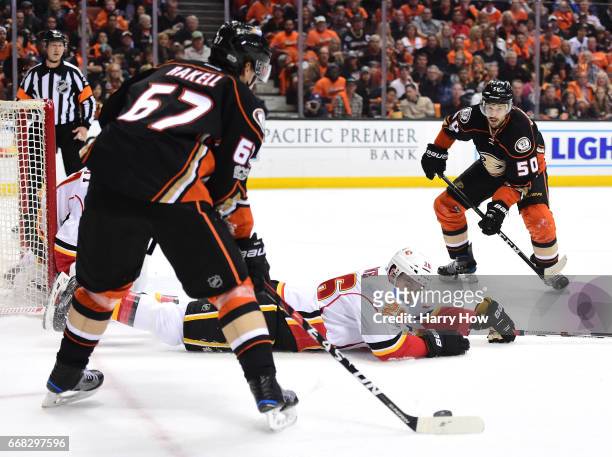 Michael Stone of the Calgary Flames attempts to block a pass from Rickard Rakell to Antoine Vermette of the Anaheim Ducks during the first period in...