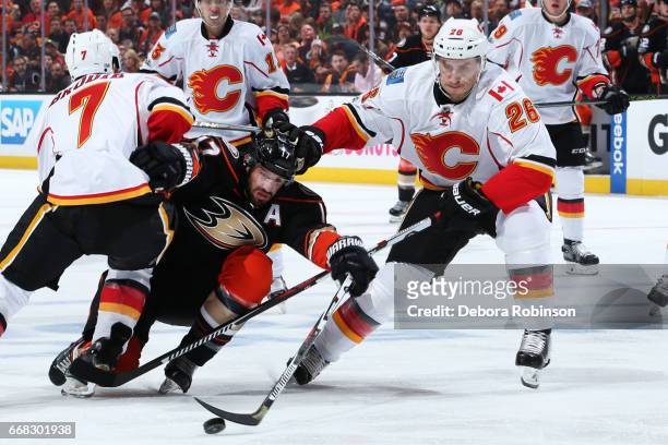 Ryan Kesler of the Anaheim Ducks battles for the puck against Michael Stone and T.J. Brodie of the Calgary Flames in Game One of the Western...