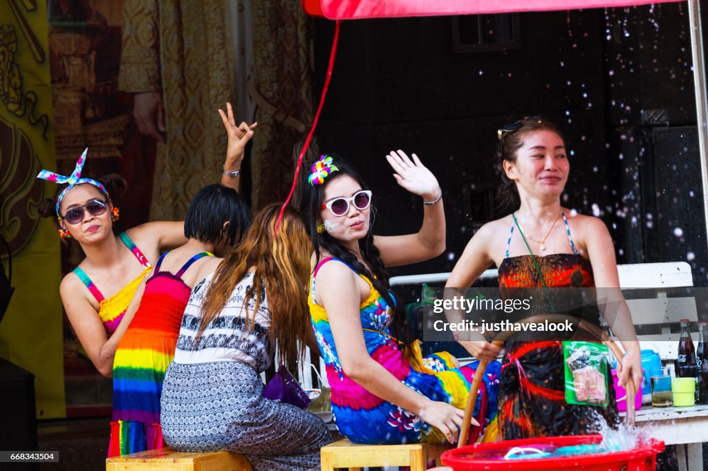 Thai women having Songkran party on sidewalk