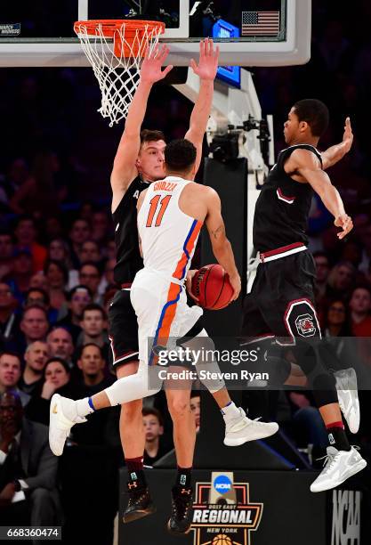 Chris Chiozza of the Florida Gators attempts a shot defended by Maik Kotsar and PJ Dozier of the South Carolina Gamecocks during the second half of...