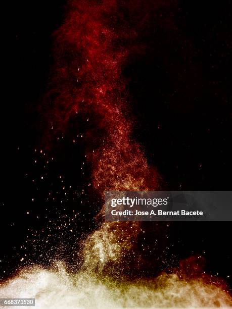explosion of a cloud of powder of particles of orange color on a black background - etéreo stockfoto's en -beelden