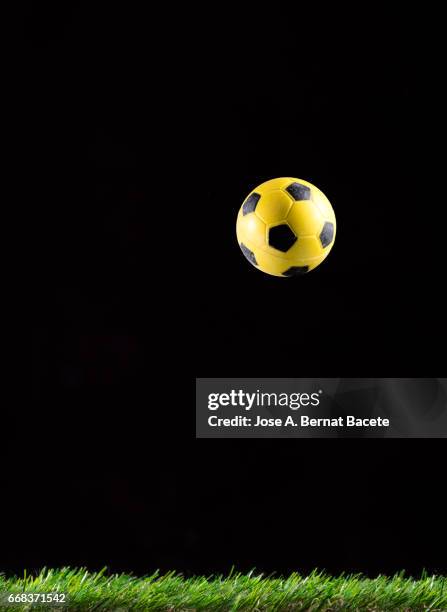 ball of  soccer,  ball bouncing on a surface of  grass soccer field, on a black bottom - abstracto photos et images de collection