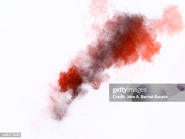 explosion of a cloud of powder of particles of  colors red and gray on a white background - con textura stockfoto's en -beelden