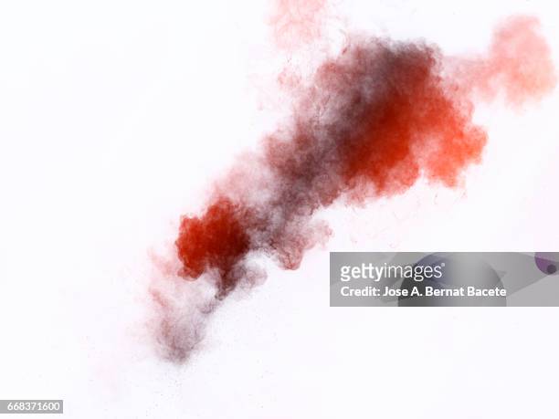 explosion of a cloud of powder of particles of  colors red and gray on a white background - peligro stock pictures, royalty-free photos & images