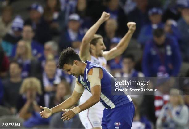 Lindsay Thomas of the Kangaroos reacts on the final siren as Marcus Bontempelli of the Bulldogs celebrates during the round four AFL match between...