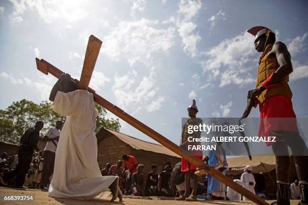 South Sudanese actor Emmanuel Aban , as a Jesus Christ, carries the cross during the Good Friday procession ahead of Easter in Juba, South Sudan on...