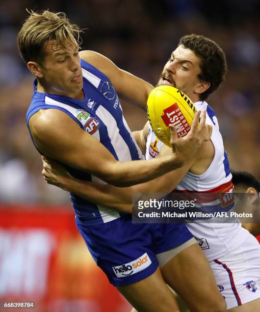 Shaun Higgins of the Kangaroos is tackled by Tom Liberatore of the Bulldogs during the 2017 AFL round 04 match between the North Melbourne Kangaroos...