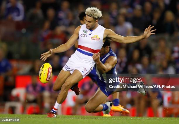 Jason Johannisen of the Bulldogs is tackled by Robbie Tarrant of the Kangaroos during the 2017 AFL round 04 match between the North Melbourne...