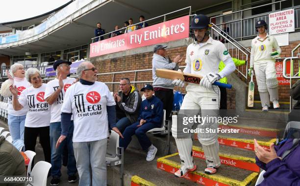 Durham opening batsmen Stephen Cook and Keaton Jennings walk out to bat as Durham supporters with 'It's not cricket' T-Shirts look on before day one...