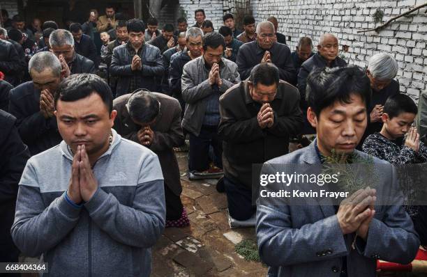 Chinese Catholic worshippers kneel and pray during Palm Sunday Mass during the Easter Holy Week at an "underground" or "unofficial" church on April...