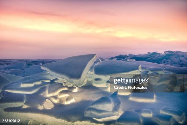 ice hummock with flash of light at ice of lake baikal on sunset - bai tribe stock pictures, royalty-free photos & images