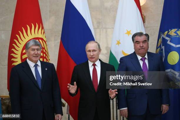 Russian President Vladimir Putin gestures as Kyrgyz President Almazbek Atambayev and Tajik President Emomali Rakhmon look on during the Summit of...