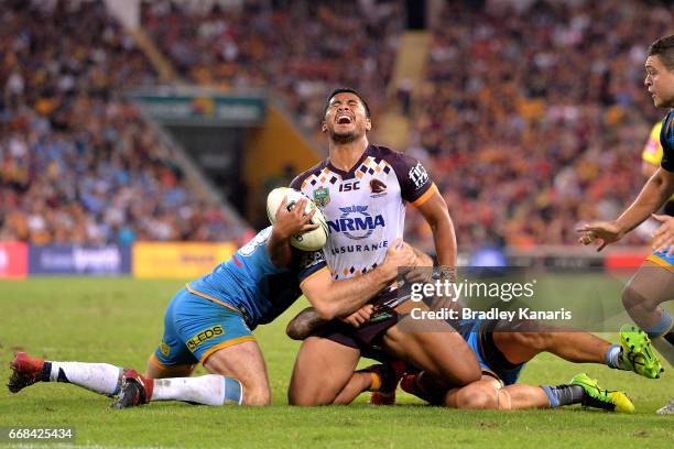 Anthony Milford of the Broncos looks to be in pain as he is tackled during the round seven NRL match between the Brisbane Broncos and the Gold Coast...