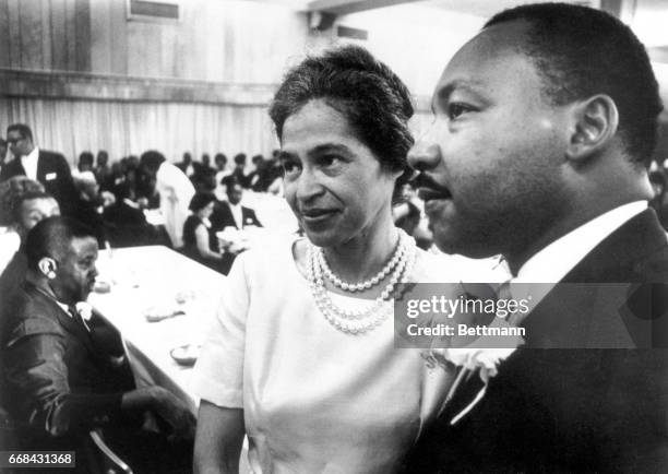 Dr. Martin Luther King stands with Rosa Parks at dinner given in her honor during Southern Christian Leadership Conference convention held here 8/10...