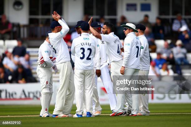 Ajmal Shahzad of Sussex celebraates with team-mates after claiming the wicket of Joe Denly of Kent during day one of the Specsavers County...