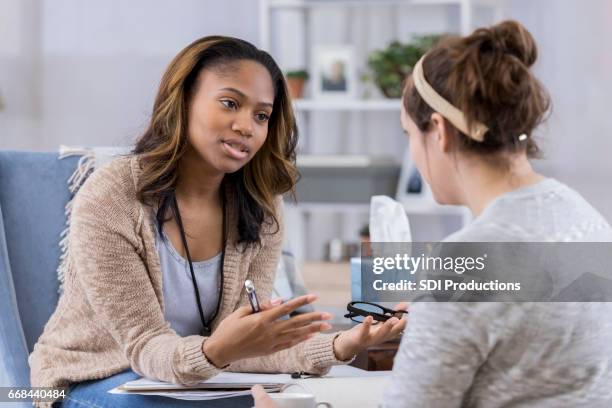 junge weibliche ratgeber gespräche mit kunden - psychiatrie und psychotherapie stock-fotos und bilder