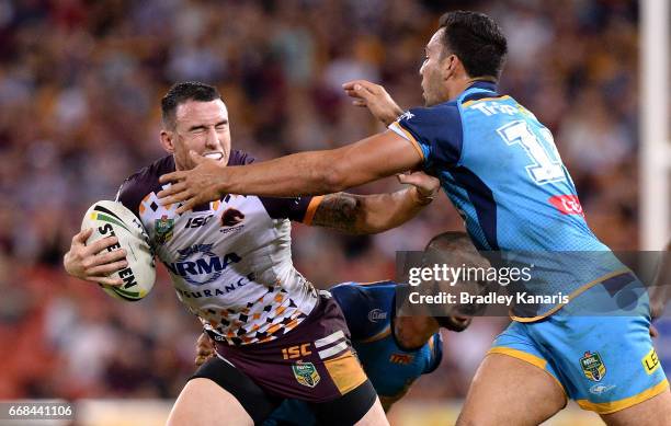 Darius Boyd of the Broncos pushes away from the defence during the round seven NRL match between the Brisbane Broncos and the Gold Coast Titans at...