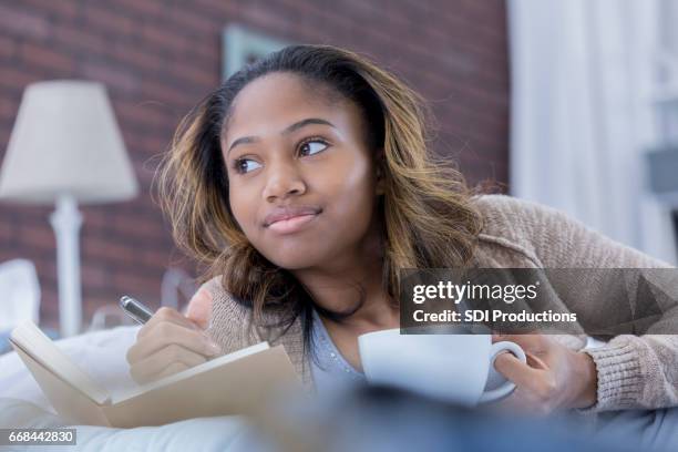 african american woman dagdrömmar medan du skriver i journalen - teenager dream work bildbanksfoton och bilder