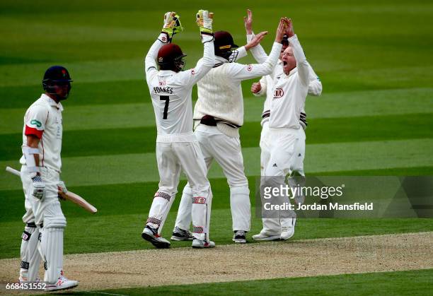Gareth Batty of Surrey celebrates with his teammates after getting the wicket of Ryan McLaren of Lancashire during day one of the Specsavers County...