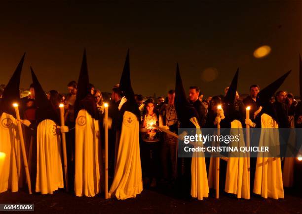 Penitents of 'La Esperanza de Triana' brotherhood parade during a Holy Week procession on April 14, 2017. Compartir Imagen para boceto...