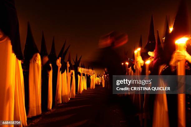 Penitents of 'La Esperanza de Triana' brotherhood parade during a Holy Week procession on April 14, 2017. Compartir Imagen para boceto...