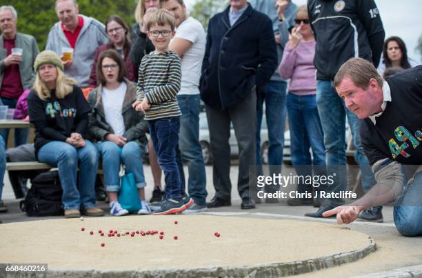 Competitor from the 'Handcross 49'ers' team takes a shot at the World Marble Championships at the Greyhound pub on April 14, 2017 in Crawley, West...