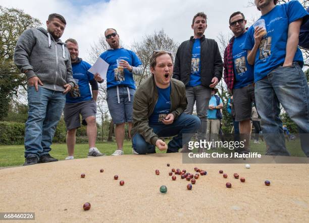 Competitor from the 'Charlwood Strikers' team reacts after taking a shot on the practice ring at the World Marble Championships at the Greyhound pub...