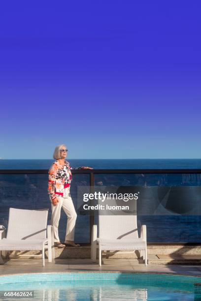 elegante oude dame in de buurt van het zwembad swimmimg - relaxamento stockfoto's en -beelden