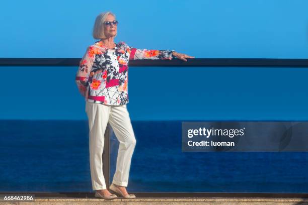 elegante oude dame buiten voor de zee - etnia caucasiana stockfoto's en -beelden