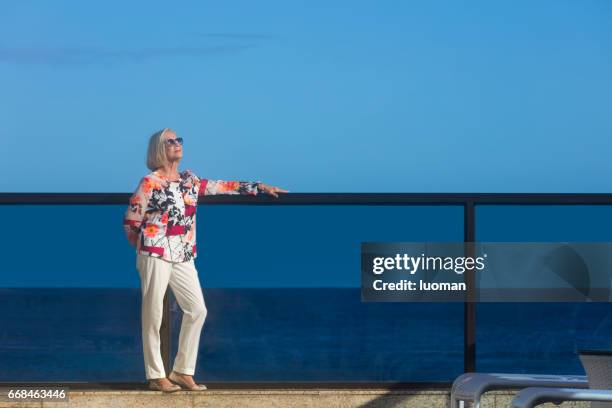 elegante dama de edad cerca de la piscina - mulheres fotografías e imágenes de stock