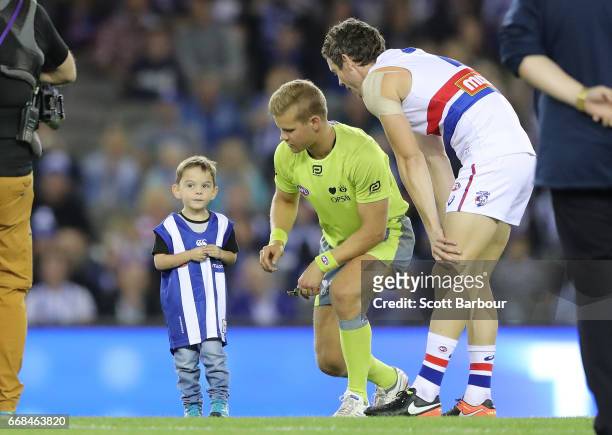Jedd Arrowsmith who has had 3 open heart surgeries in 6 years tosses the coin as Robert Murphy of the Bulldogs looks on during the round four AFL...