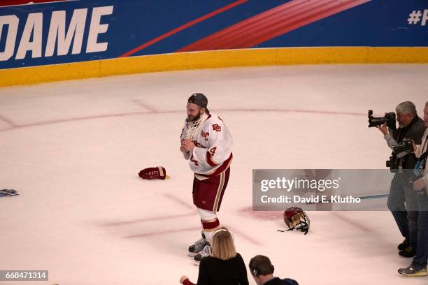 Frozen Four: Denver Will Butcher victorious, wearing cut net around neck on ice after winning game vs Minnesota Duluth at United Center. Chicago, IL...