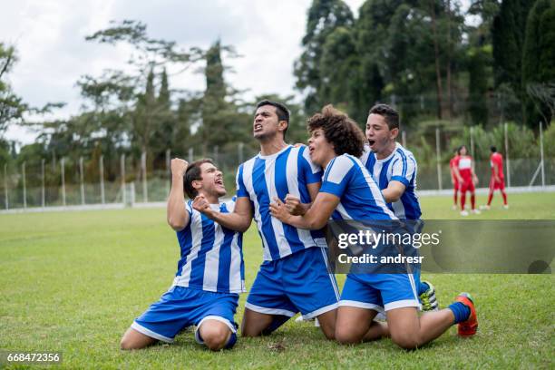 excited football team celebrating a goal - football player celebrating stock pictures, royalty-free photos & images