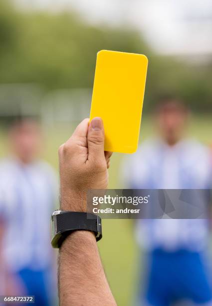 referee showing a yellow card at a soccer game - fault sports stock pictures, royalty-free photos & images