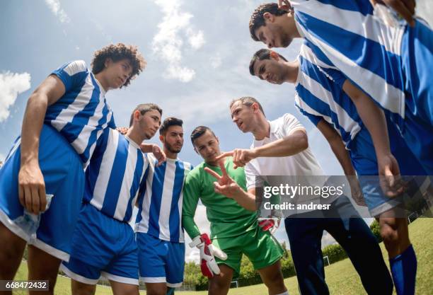 trainer im gespräch mit einer gruppe von fußball-spieler - football training stock-fotos und bilder