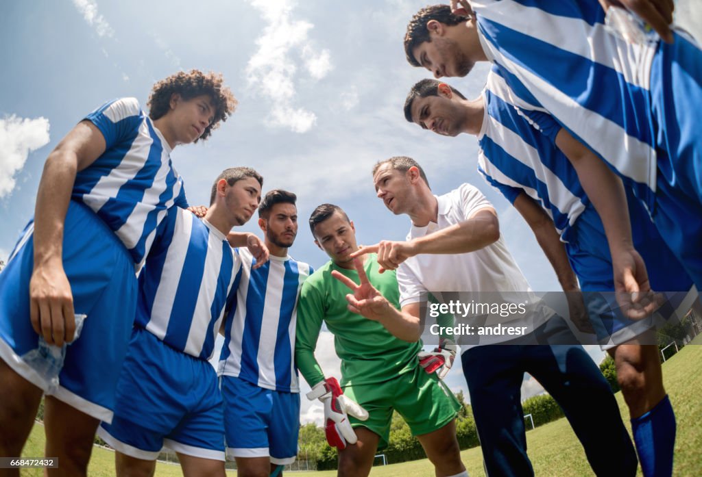 Coach talking to a group of soccer players