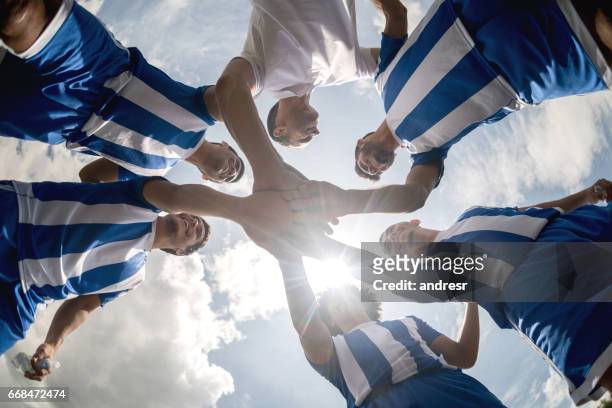 soccer team with hands together on the field - soccer team stock pictures, royalty-free photos & images