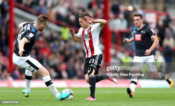 Lasse Vibe of Brentford is chased by Craig Bryson of Derby County and Alex Pearce of Derby County during the Sky Bet Championship match between...