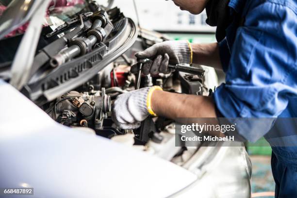 man working in automobile restoration workshop - arreglar fotografías e imágenes de stock