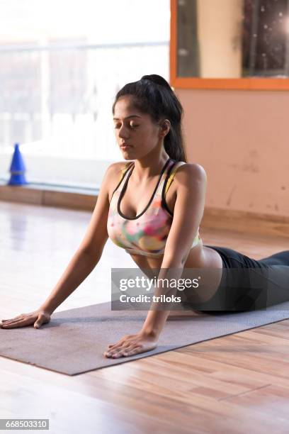 young woman practicing cobra pose - cobra stretch stock pictures, royalty-free photos & images