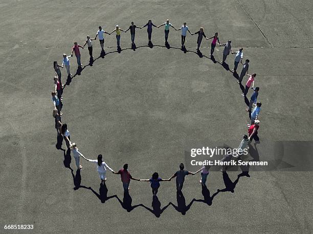 group of people forming a circle - circle of people stockfoto's en -beelden