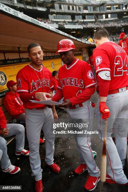 Andrelton Simmons and Infield Coach Alfredo Griffin of the Los Angeles Angels of Anaheim talk in the dugout prior to the game against the Oakland...