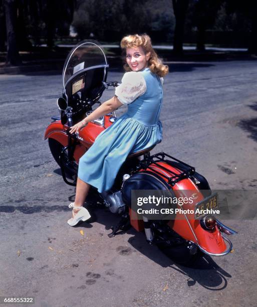 Color portrait of CBS Radio actress Ann Sothern posing with a motorcycle. She portrays Maisie Revere on the radio comedy program, The Adventures of...