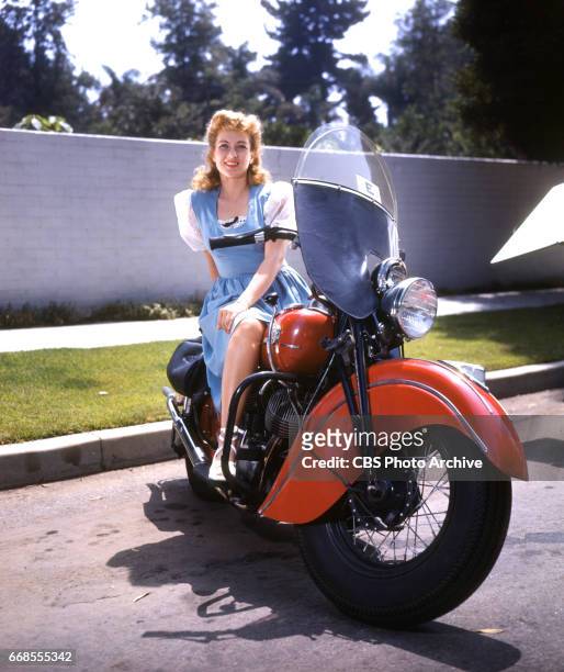 Color portrait of CBS Radio actress Ann Sothern posing with a motorcycle. She portrays Maisie Revere on the radio comedy program, The Adventures of...