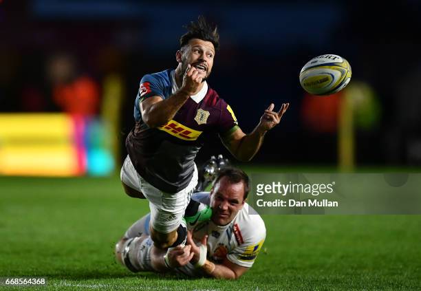 Danny Care of Harlequins offloads as he is tackled by Kai Horstmann of Exeter Chiefs during the Aviva Premiership match between Harlequins and Exeter...