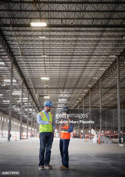 Project Manager Brad Foster of Denver, Colorado and Amazon Construction Manager Hope Hall of Phoenix, Arizona chat before a tour of a new Amazon...